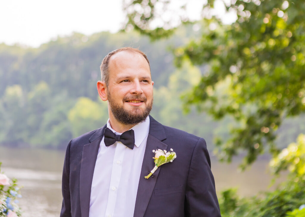 Groom catching the first glimpse of his bride walking down the aisle at their NH wedding venue with mountain views.