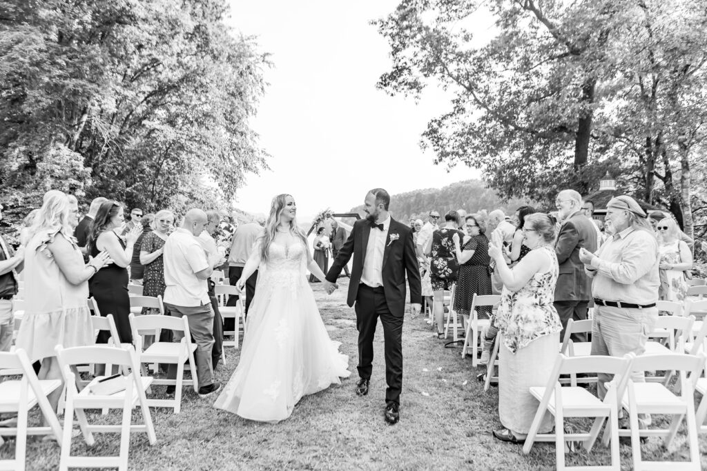 Bride and groom celebrate being married walking down the aisle.