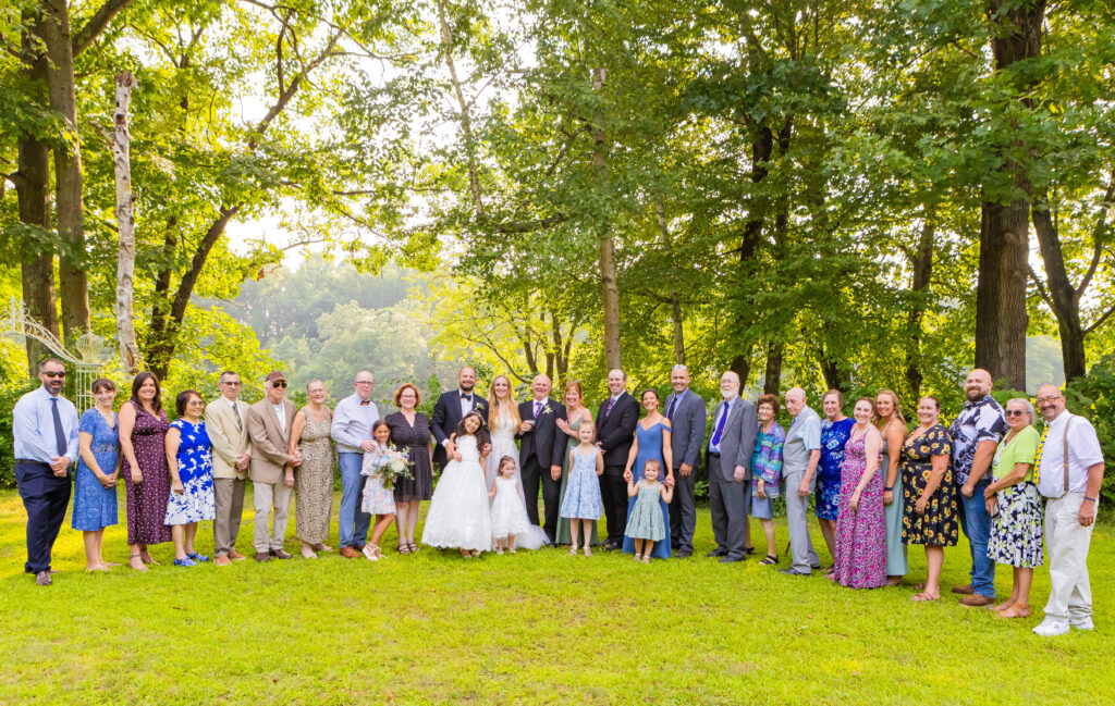 Large family poses together for Melanie and Paul's wedding day at Stone Garden.