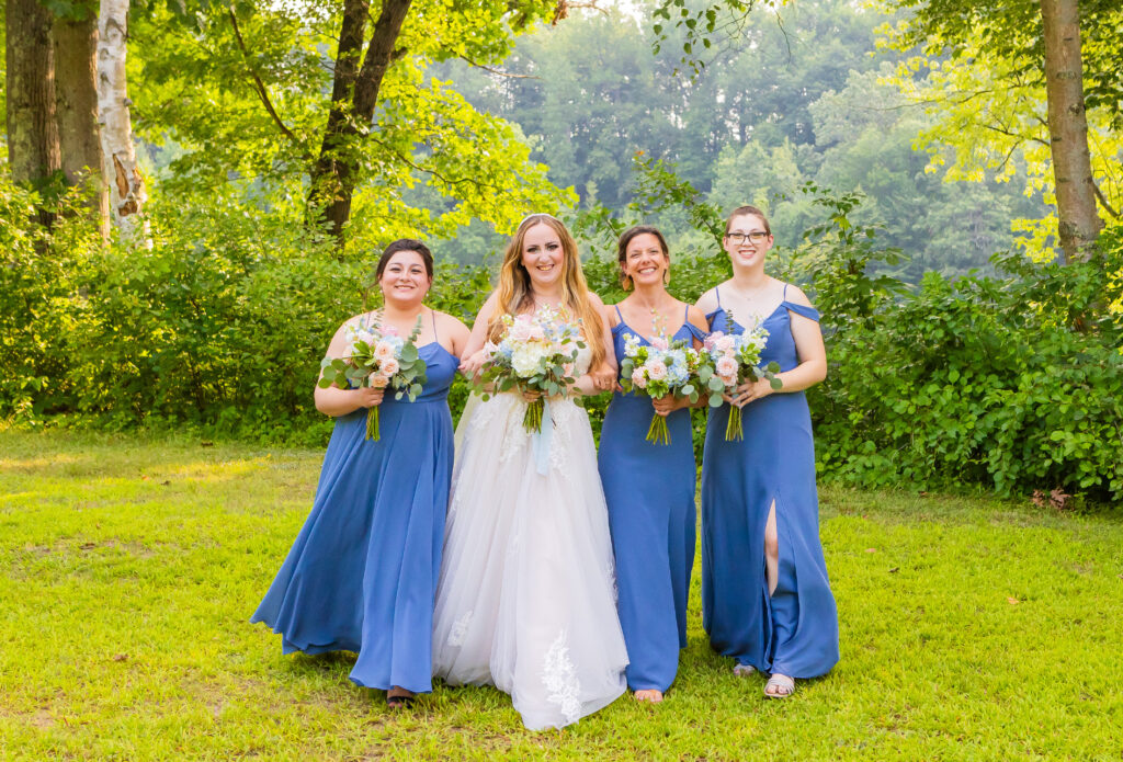 Bridal party walk together in their slate blue bridesmaid dresses.