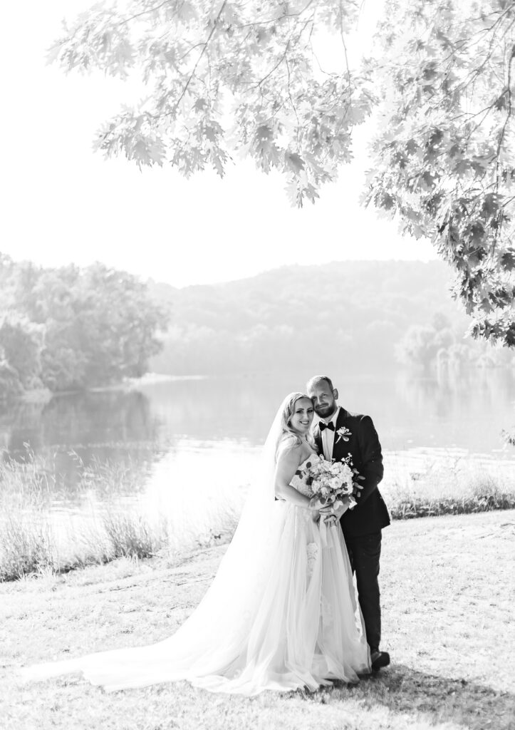 Bride and groom standing under a willow tree at their wedding at Stone Garden.