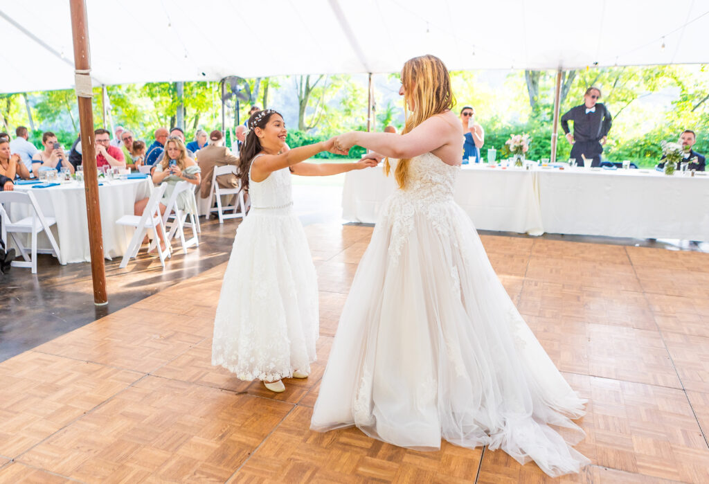 Bride and daughter sharing a dance at their greenhouse wedding venue in New England.