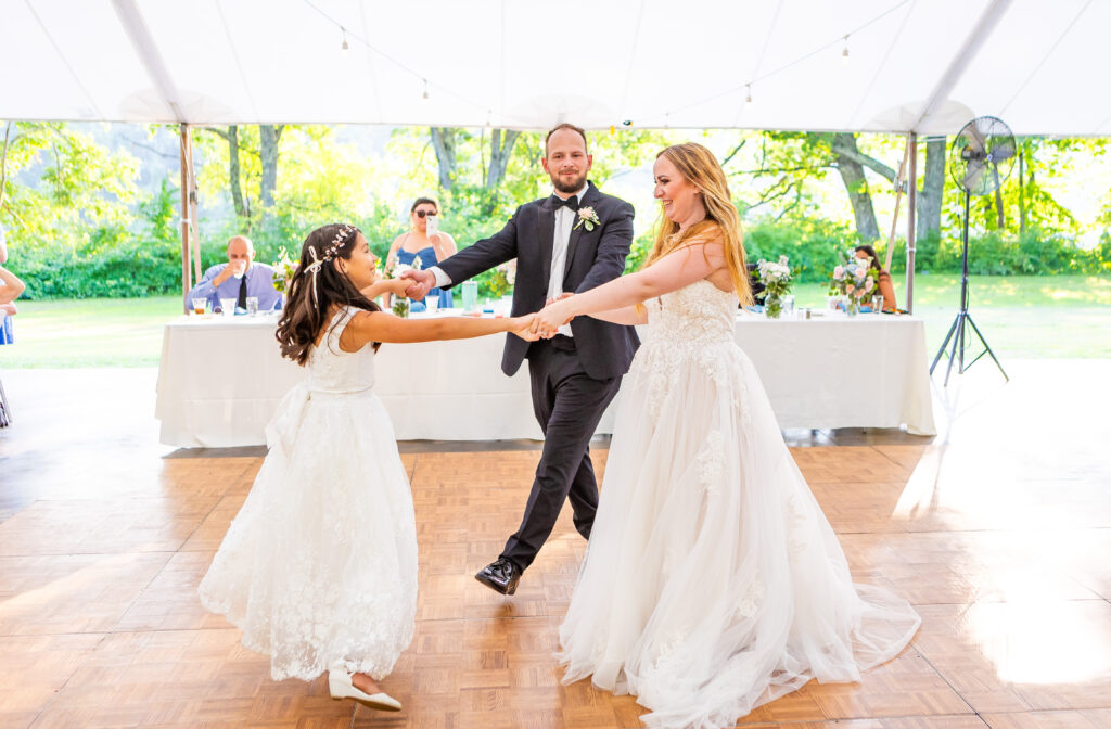 Bride and groom sharing a dance with their daughter on their wedding day at Stone Garden.