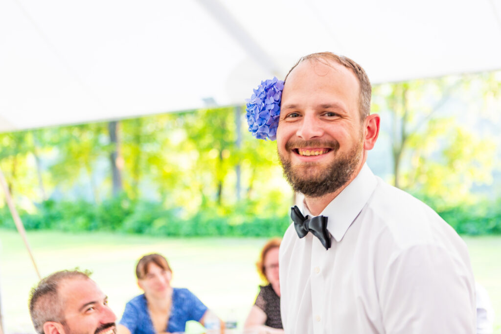 Groom wears flowers on his head as a silly joke.