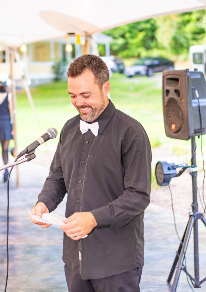 Best man giving his speech at a riverfront wedding venue in New England.