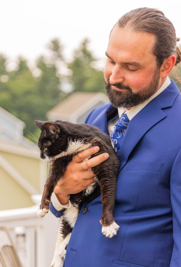 Groom holding his cat while getting ready for his wedding.