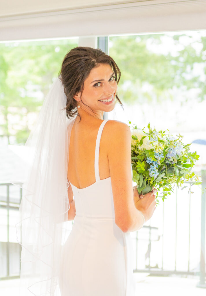 Bride looks over her shoulder in her gown from a NH bridal store.