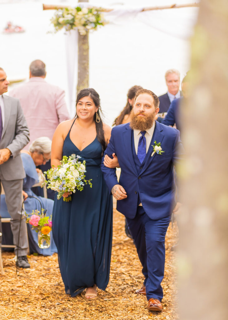 Groomsmen and bridesmaid walk back up the wedding ceremony aisle.