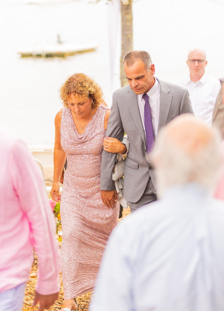 Wedding guests walk up the aisle to greet the bride and groom.