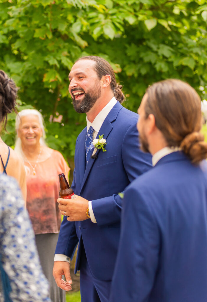 The groom candidly laughing.