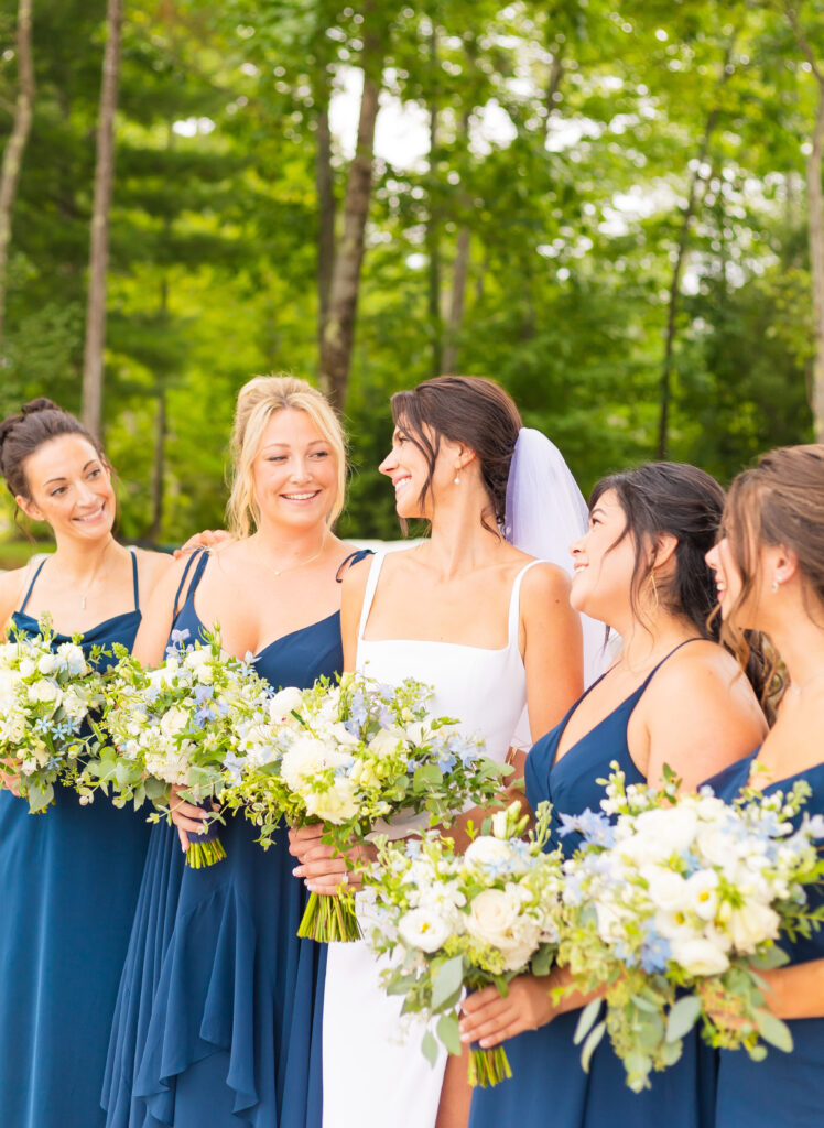 Bridesmaids smiling at eachother at a NH lake wedding venue