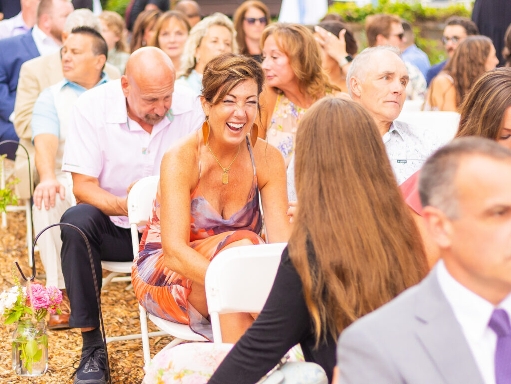 Wedding guest laughing with another guest.