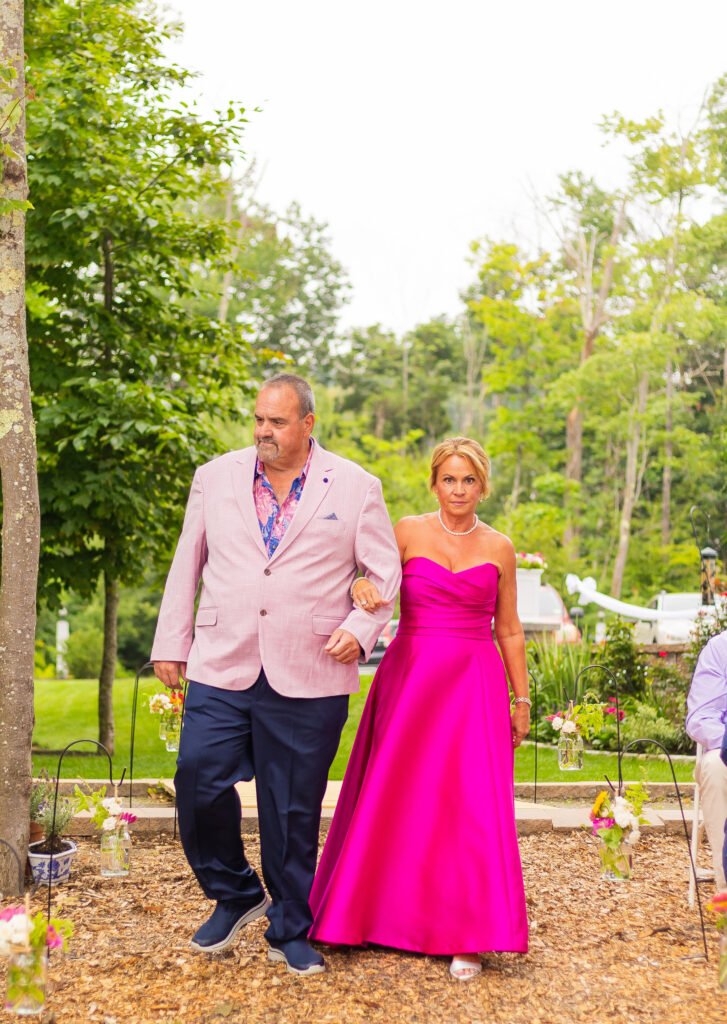 Grooms parents walking down the aisle together.