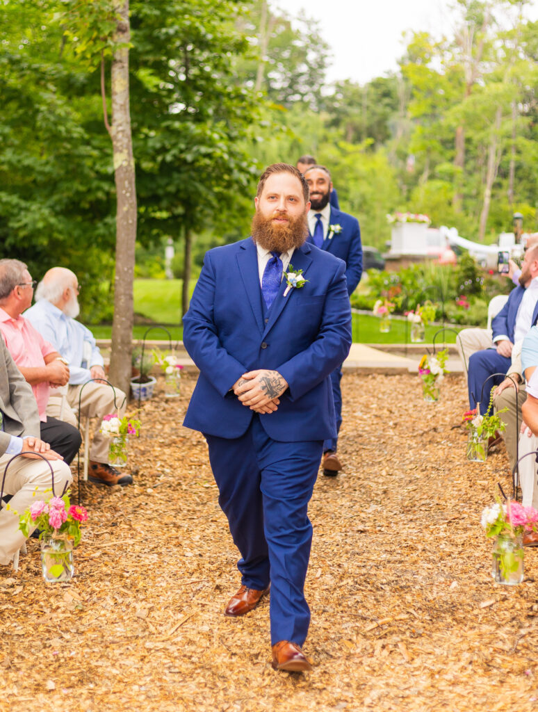 Groomsmen walking down the aisle overlooking Lake Winnipesaukee.