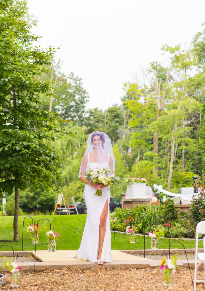 Bride walks down the aisle to her wedding ceremony on Lake Winnipesaukee.