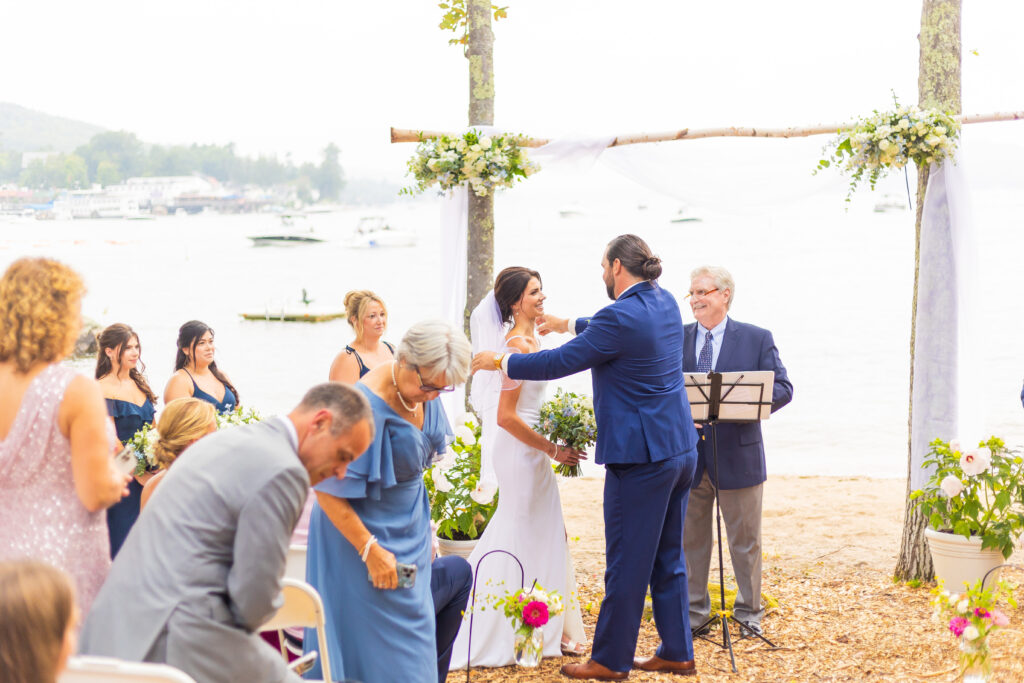 Groom removes the veil from the brides face.