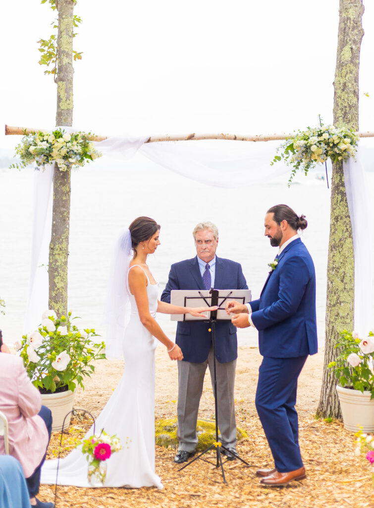 Bride and groom exchange rings at their Lakes Region wedding.