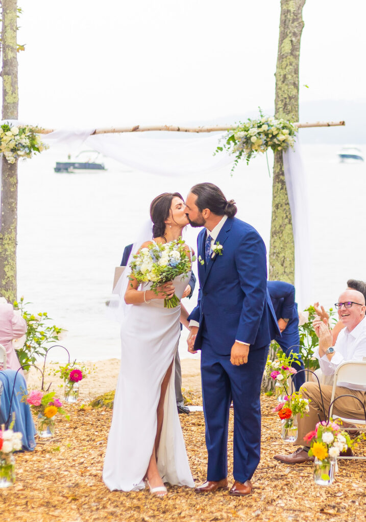 Bride and groom share an aisle kiss.