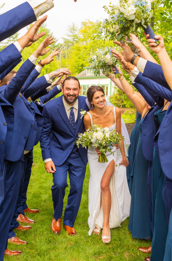 Bride and groom walk through the tunnel made by their wedding party at their White Mountain wedding.