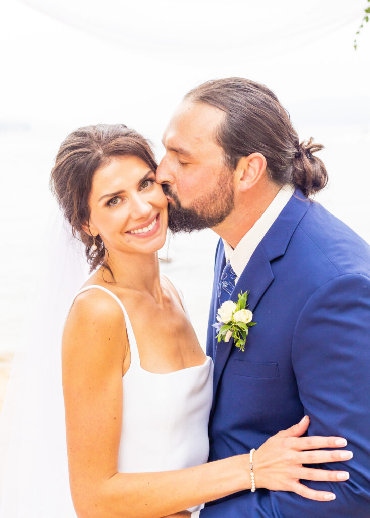 Groom kisses the bride on the at their luxury backyard wedding in southern NH.