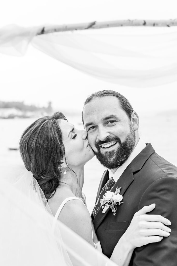 Bride kisses the groom on the cheek.