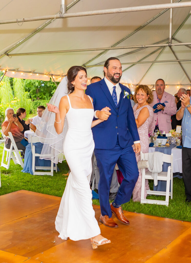 Bride and groom walking into their reception