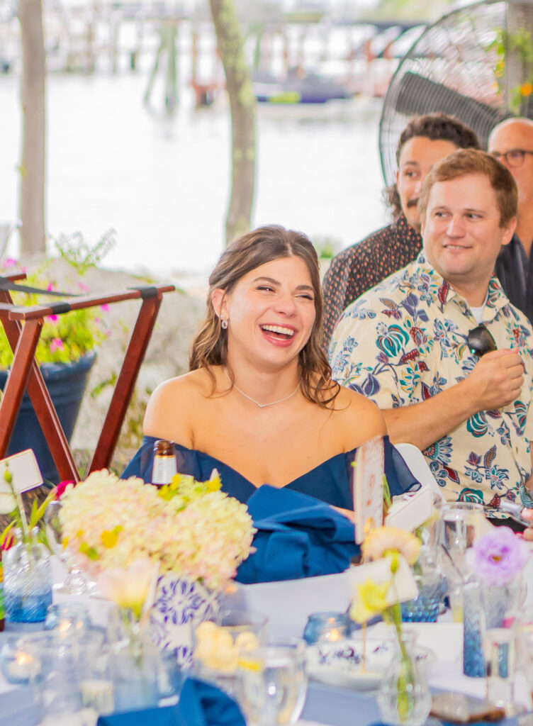 Bridesmaid laughing at a comment made during a wedding speech.