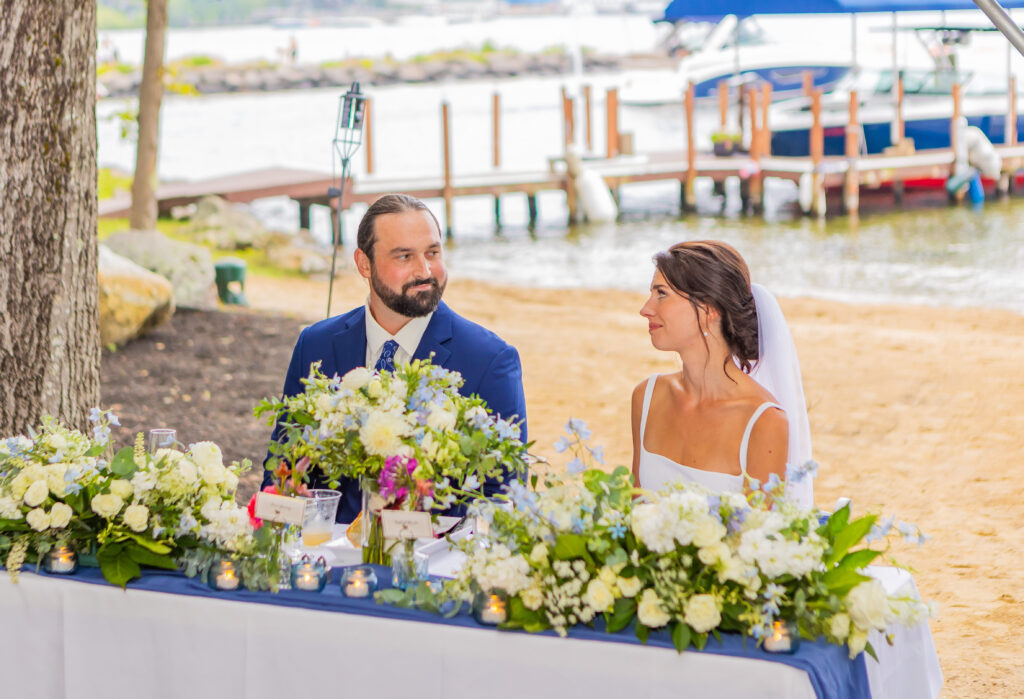 Bride and groom look at each other with love during speeches.