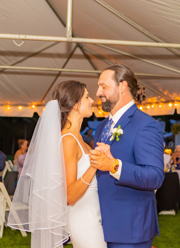 Bride and groom hold hands and share their first dance.