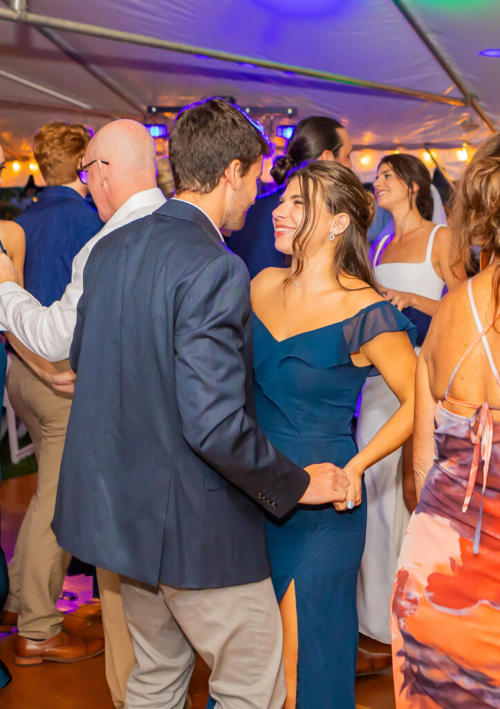 Bridesmaid dancing with her boyfriend at a wedding.