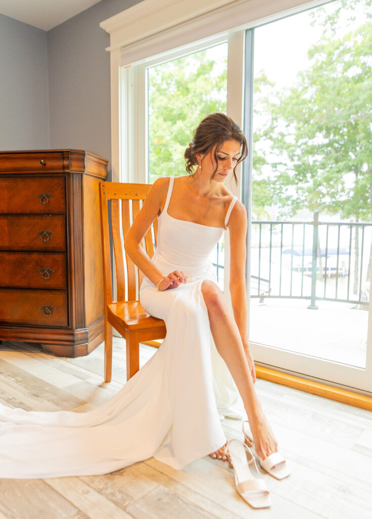 Bride puts her wedding shoes on right before her Lake Winnipesaukee wedding on Weirs Beach.