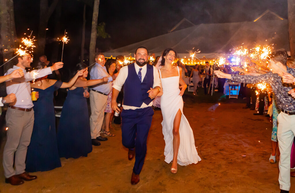 Bride and groom run down the aisle of their sparkler exit.