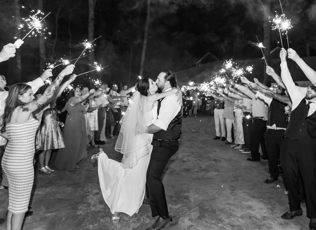 Bride and groom sharing a kiss during their sparkler exit.