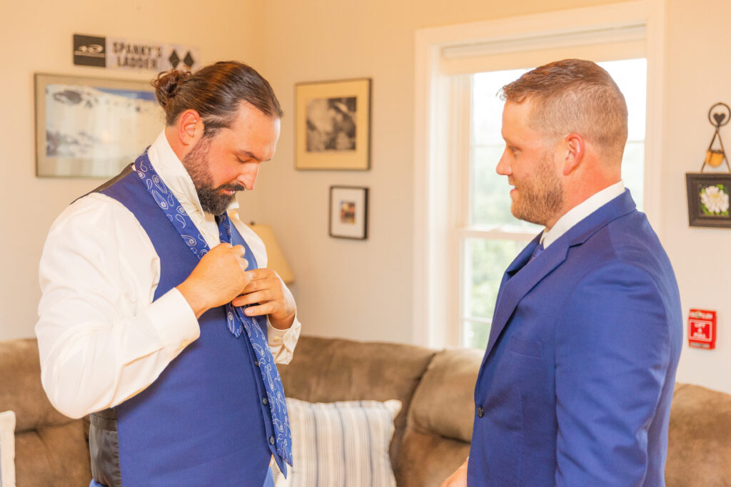 Groom is adjusting his tie.