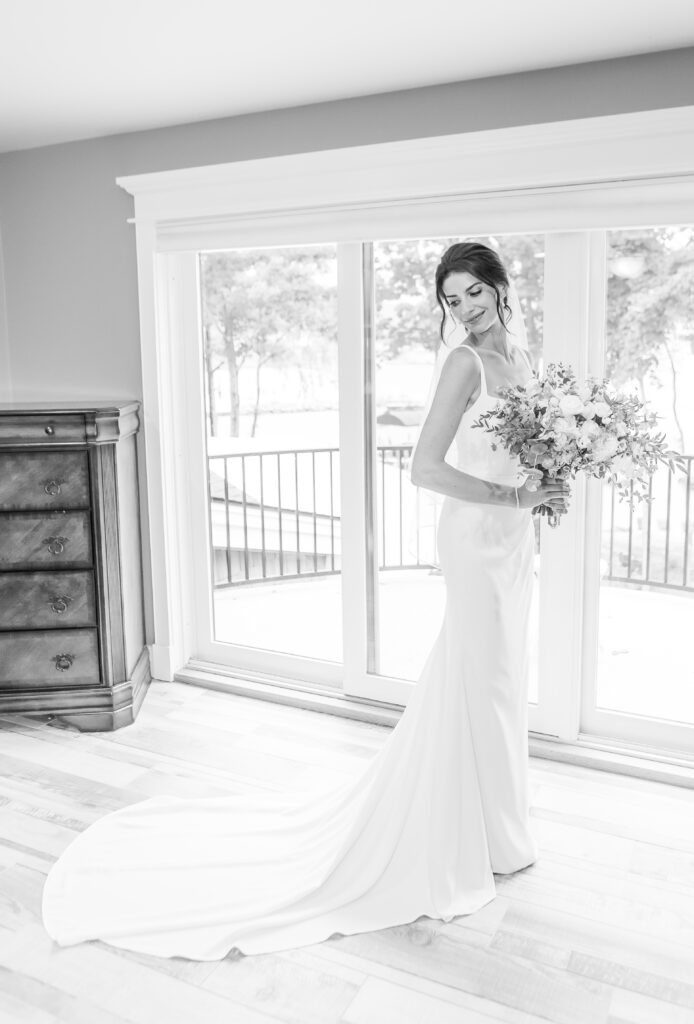 Bride looks over her shoulder after finishing getting ready for her wedding in Laconia, NH