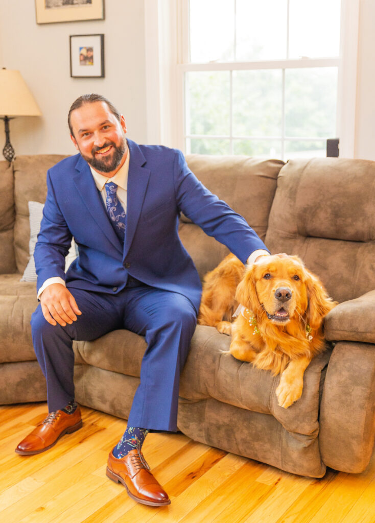 Groom petting his dog while getting ready for his wedding on Lake Winnipesaukee.