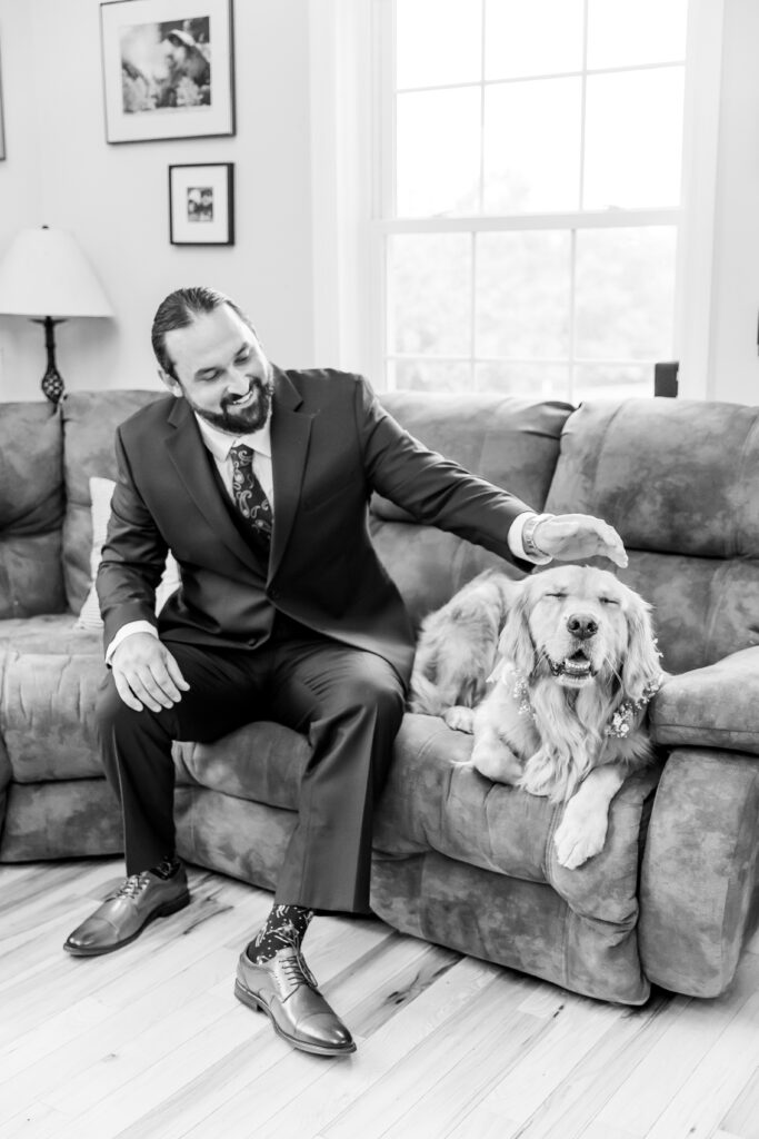 Dog getting pet by the groom on his wedding day.