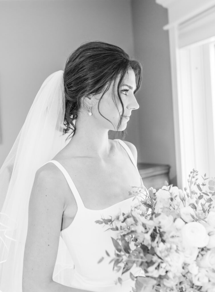 Bride looks out the window at her Weirs Beach wedding venue.