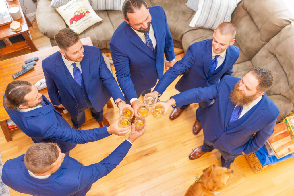 Groomsmen cheers at a romantic NH Lakes Region Wedding.