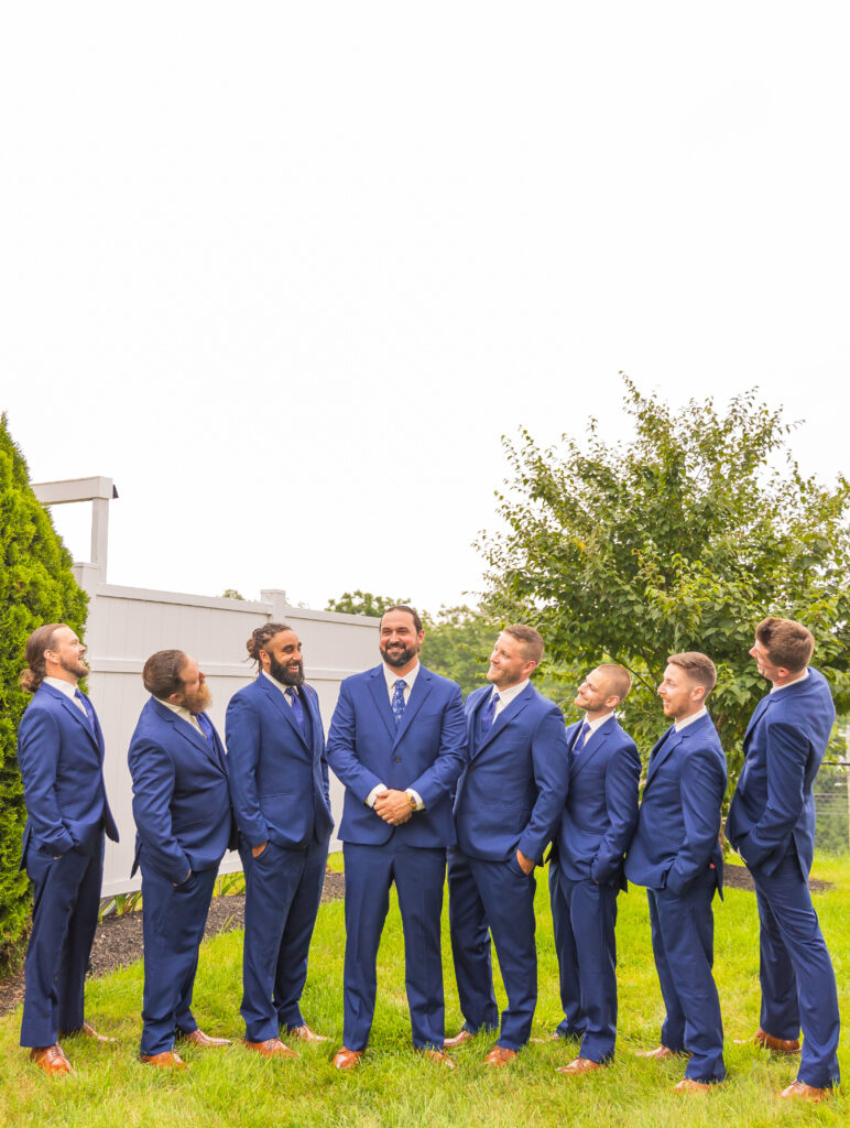 Groomsmen laugh at eachother at their getting ready location.