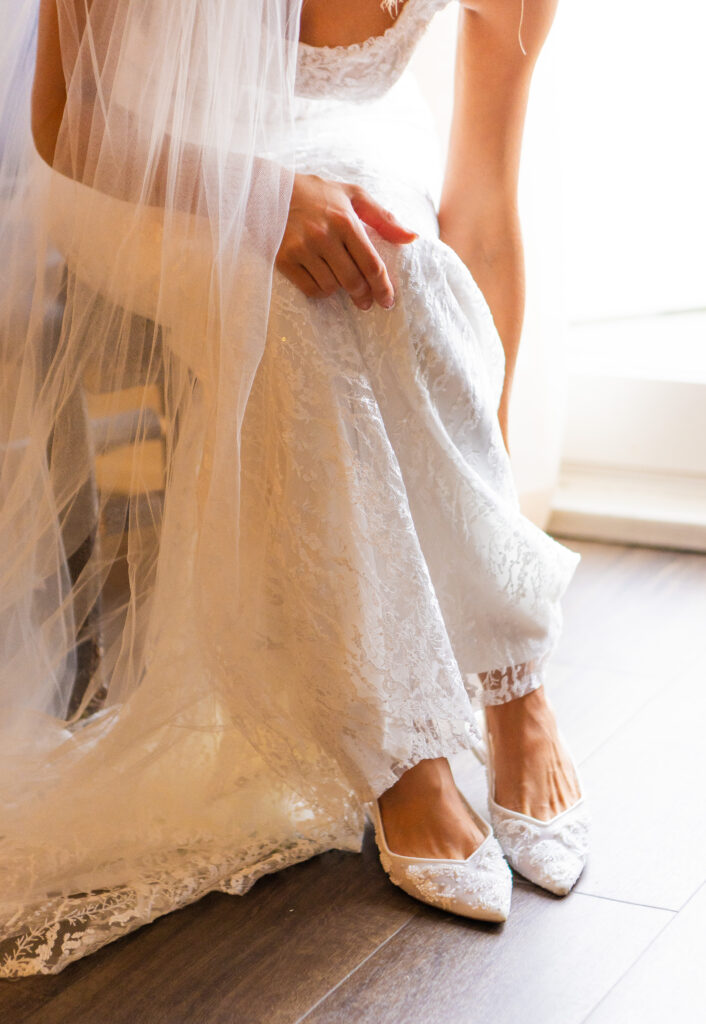 bride slides her wedding flats on