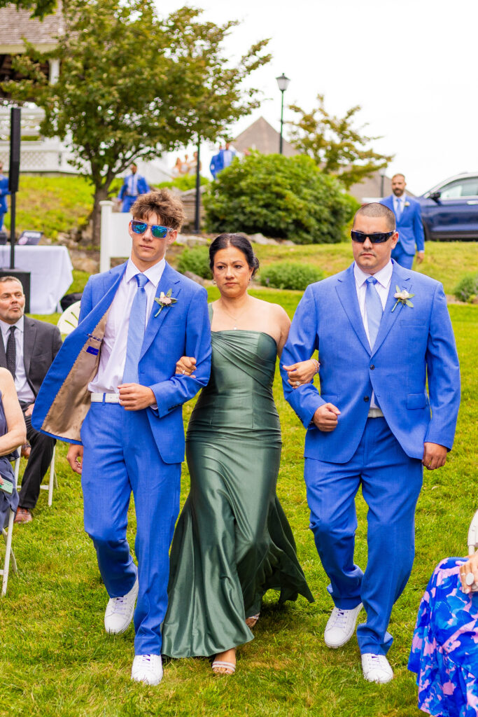 mother of the bride and groomsmen walk down the aisle