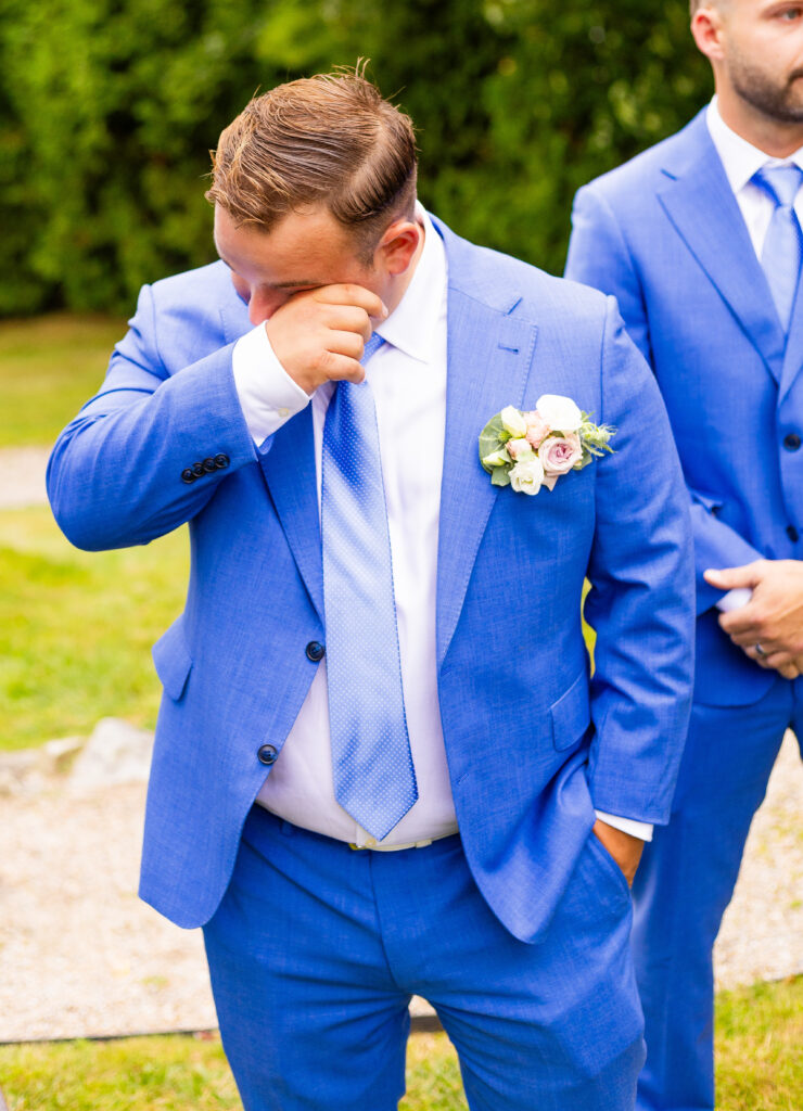 groom wipes tears at wedding ceremony