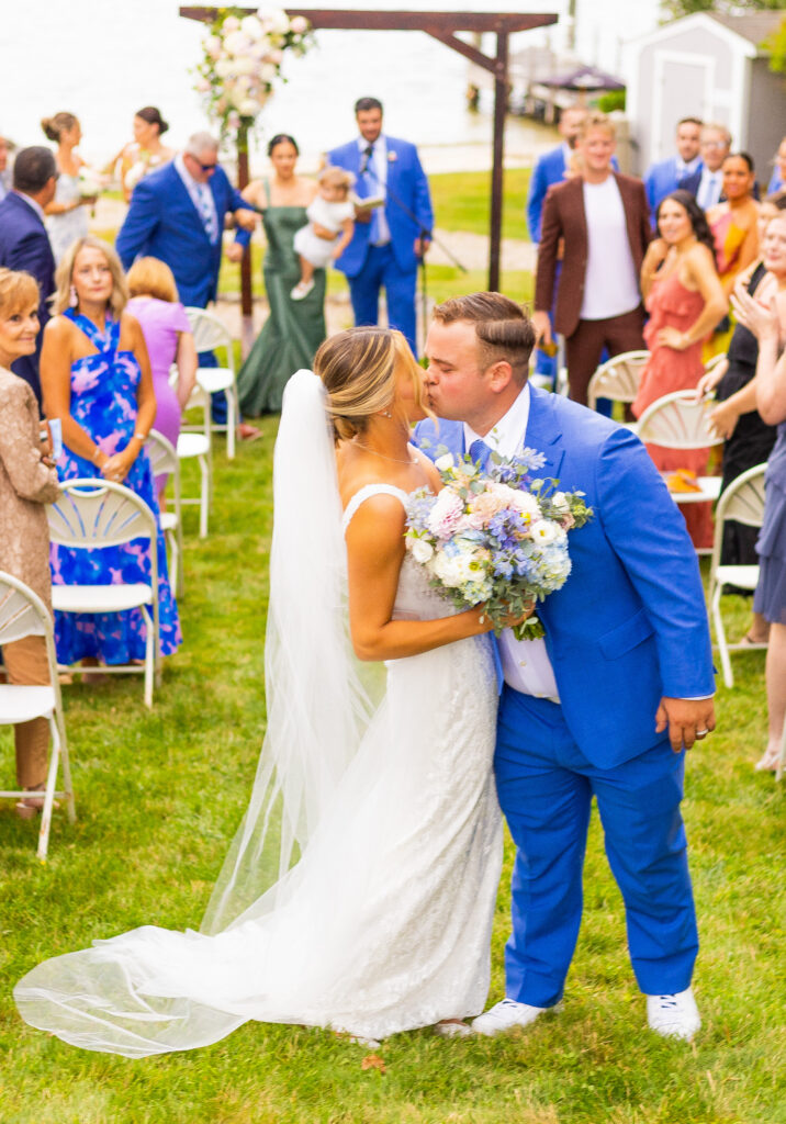 bride and groom share a kiss in the aisle 