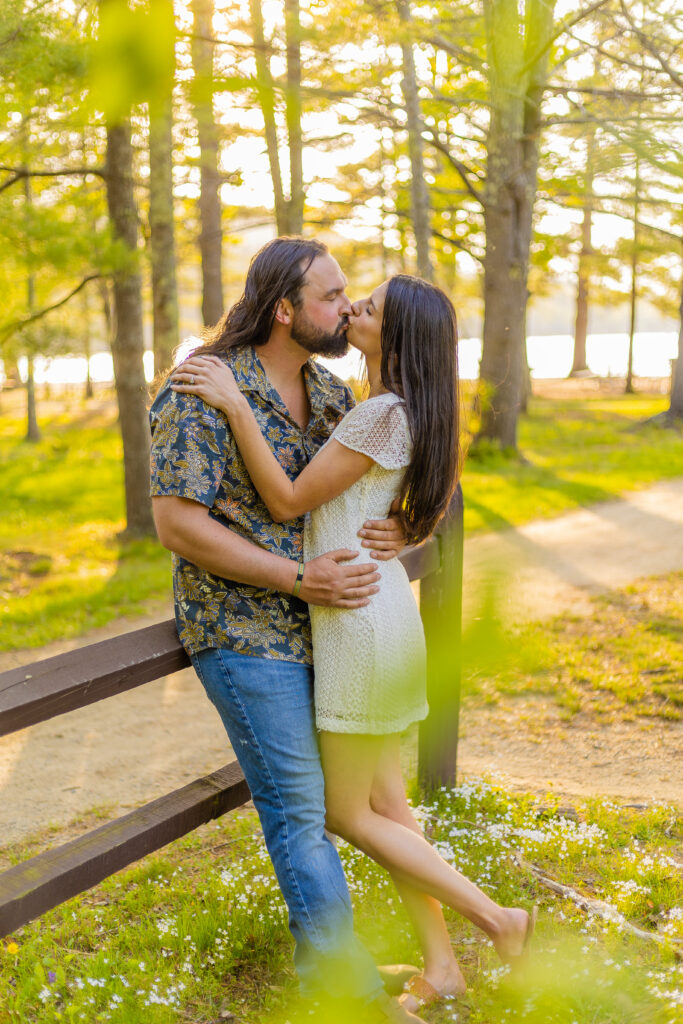 A couple share a kiss at their engagement session at Ellacoya State Park in Gilford, New Hampshire.