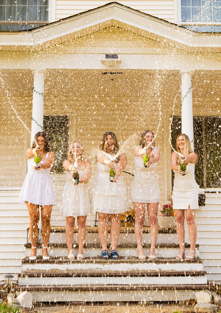 Girls doing a champagne spray at Plymouth State University for their NH grad session.